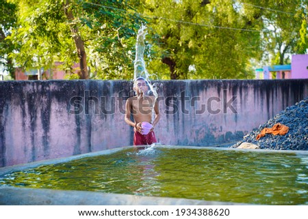 Cute indian poor child enjoy bathing in open place
