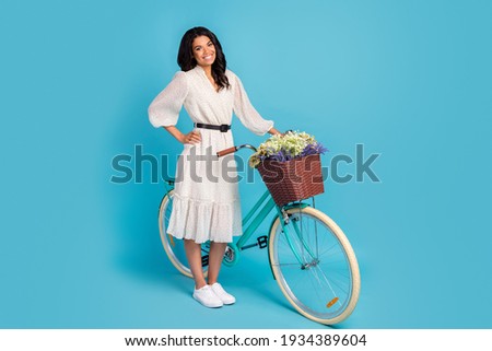 Full length body size view of attractive elegant cheerful girl with bike free spare time rest isolated over bright blue color background