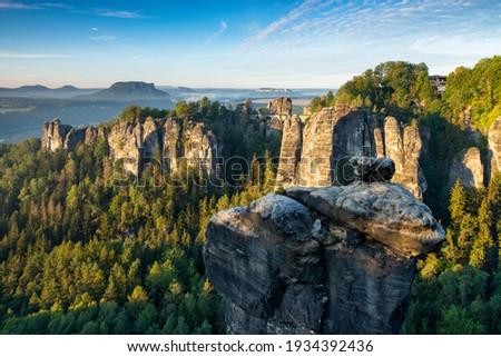 View to the Bastei Bridge and Rock Formations in the Elbe River Valley in the warm light of the rising sun, Saxon Switzerland National Park, Germany Royalty-Free Stock Photo #1934392436