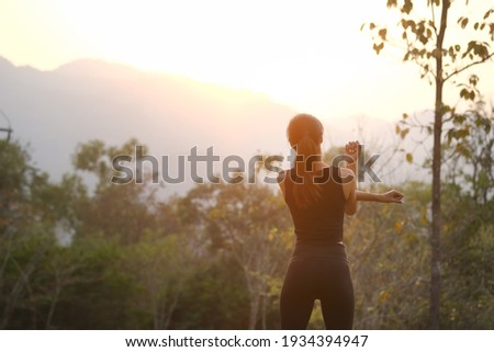 Rear view healthy young woman stretching in the park before running at the sunset. Royalty-Free Stock Photo #1934394947