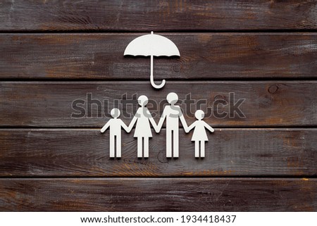 Family figure under umbrella. Insurance and family protection concept