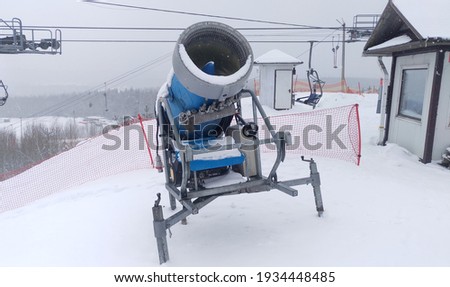 The snow cannon stands on a ski slope and is used to produce artificial snow in frosty weather in winter