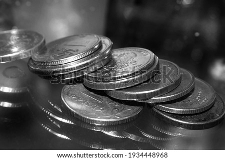 coins lie in a pile on the glass. Close up photo