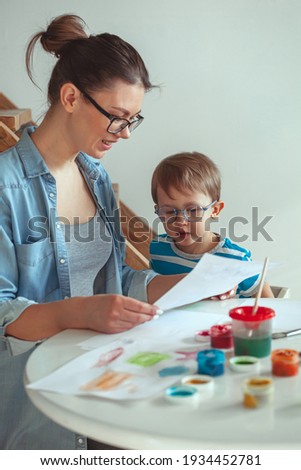 Mom and child paint together at home with a dog