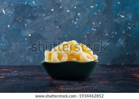 Corn sticks in dark blue bowl, on galaxy blue background. High quality photo