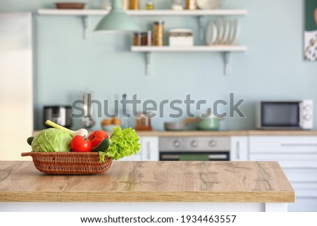 Basket with fresh vegetables on kitchen table