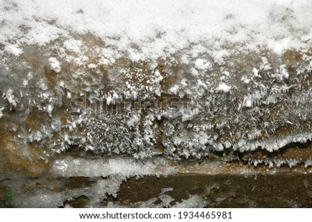frost on the wooden wall near the font
