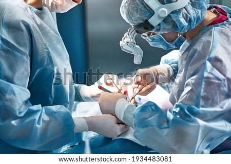 Rhinoplasty men, the surgeons gloved hands hold the instruments during nose surgery Doctor in gloves holds medical instrument during rhinoplasty Royalty-Free Stock Photo #1934483081