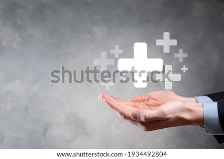 Businessman, man hold in hand offer positive thing such as profit, benefits, development, CSR represented by plus sign.The hand shows the plus sign. Royalty-Free Stock Photo #1934492804