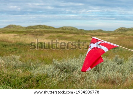 The Danish flag Dannebrog on the left and the Thy National Park in Northern Denmark