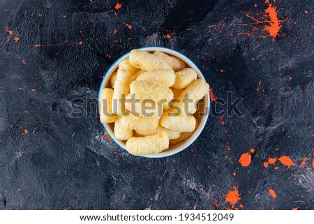 Bowl with corn sticks on navy blue table. High quality photo