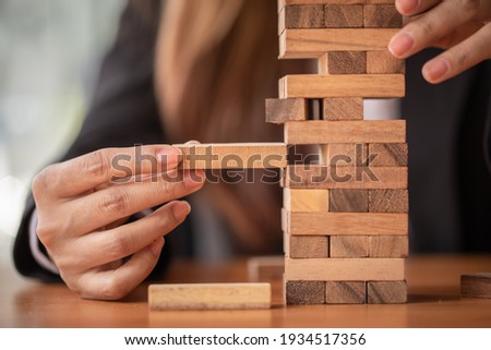 Abstract businesswomen fail danger tower block game building construction protect plan and project control. Royalty-Free Stock Photo #1934517356