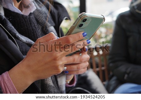 woman using mobile phone with painted nails