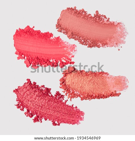 Swatches of pink powder blush on white background