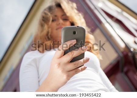 Woman using cellphone on the street. Outdoors image
