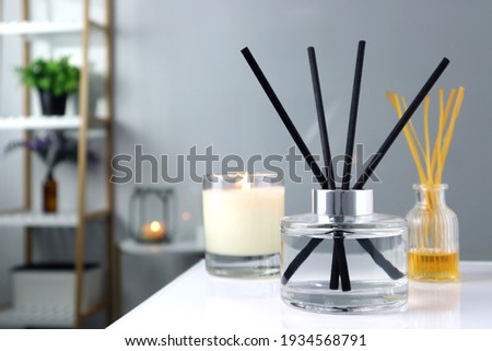 luxury glass aroma scent reed diffuser bottle is used as air freshener on the table with scented candle in the nice white living room to creat relax , cozy and clean ambient and for decoration Royalty-Free Stock Photo #1934568791