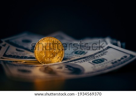 Golden bitcoin coin on us dollars close up. Electronic crypto currency

