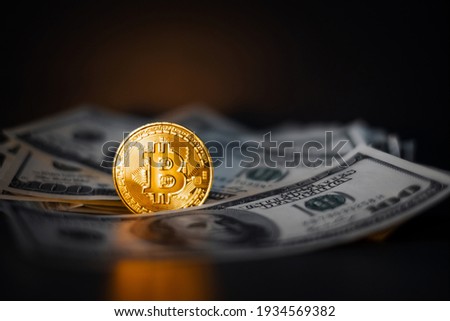 Golden bitcoin coin on us dollars close up. Electronic crypto currency
