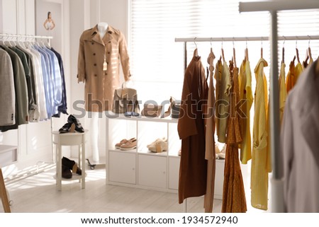 Collection of stylish women's clothes, shoes and accessories in modern boutique Royalty-Free Stock Photo #1934572940