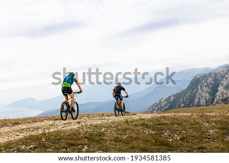 two male cyclists biking on mountain road Royalty-Free Stock Photo #1934581385