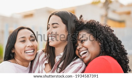Happy multiracial women hugging each other - Girls with different skin colors - Friendship and happiness concept Royalty-Free Stock Photo #1934587391