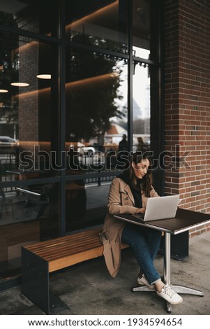 business focused confident successful freelancer adult woman blogger works using technology laptop phone communicates performs tasks studies in the workplace office in a public place in a coffee shop