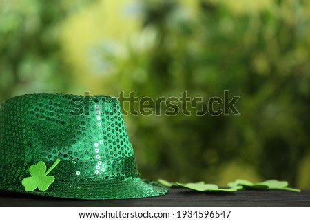Green sequin hat with clover leaf on wooden table against blurred background, space for text. St Patrick's Day celebration Royalty-Free Stock Photo #1934596547
