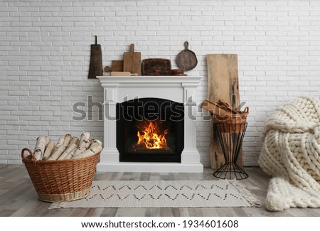 Wicker baskets with firewood and white fireplace in cozy living room