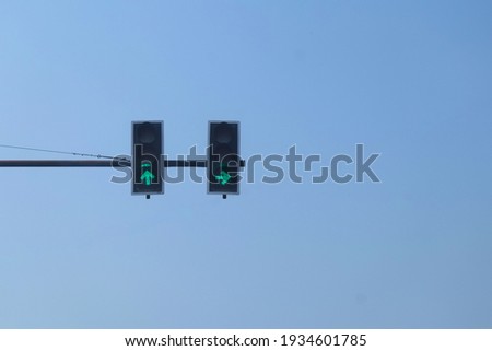 Green traffic lights on the road with blue sky.