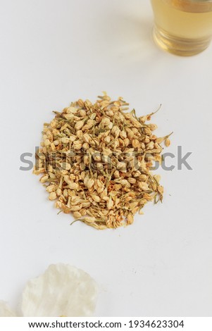 Jasmine green tea, dried jasmine and a cup of green jasmine tea on white background.  Top view, copy space, stock photo