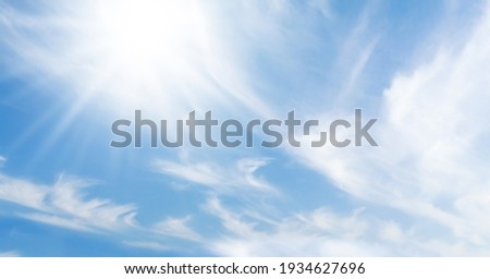 Blue sky with light clouds and bright sun. Summer sky backdrop Royalty-Free Stock Photo #1934627696