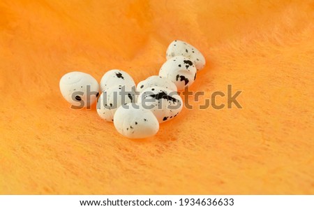Small, colorful eggs and an Easter decoration.