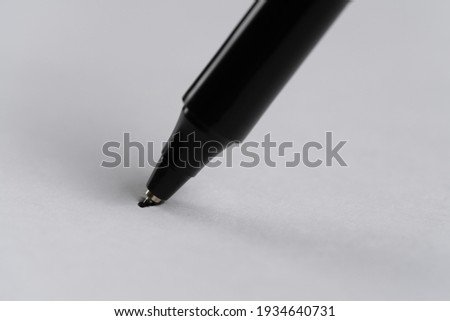 Black pen pierced through a white paper.