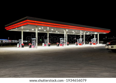 Horizontal shot of a generic unbranded gas station at night with copy space at the top and bottom. Royalty-Free Stock Photo #1934656079