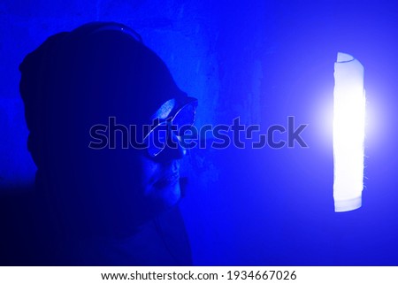 Sound recording studio. Young man in glasses and headphones on the night party in nightclub with neon lights. Have fun tonight. Holidays entertainment. Soft focused photo.