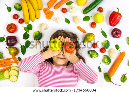 A child with vegetables and fruits in their hands. Selective focus. Food. Royalty-Free Stock Photo #1934668004