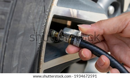 woman's hand calibrating car tire Royalty-Free Stock Photo #1934672591