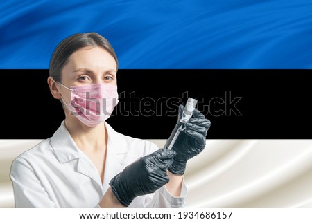 Girl doctor prepares vaccination against the background of the Estonia flag. Vaccination concept Estonia.