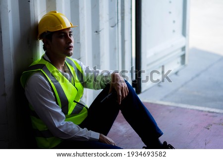 Factory worker man sit in the cargo container and lost job. Concept of good system and manager support for better industrial business. Royalty-Free Stock Photo #1934693582