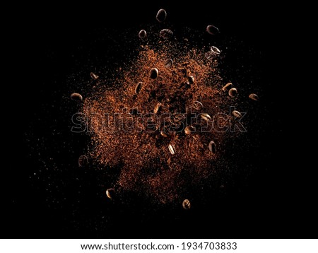 Explosion of ground coffee with roasted beans on black background Royalty-Free Stock Photo #1934703833