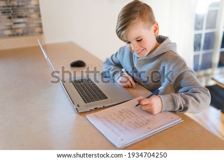 A Teenager boy doing his homework at desk indoors
