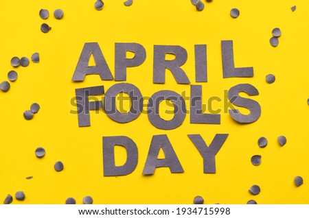 Image caption April Fools' Day of grey letters on a yellow background close-up, around confetti. High quality photo