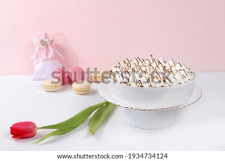 Cake with chocolate and meringue, marshmallow and flowers on a light table, festive food for mother's day, wedding, birthday. Modern bakery concept, advertising space, selective focus
