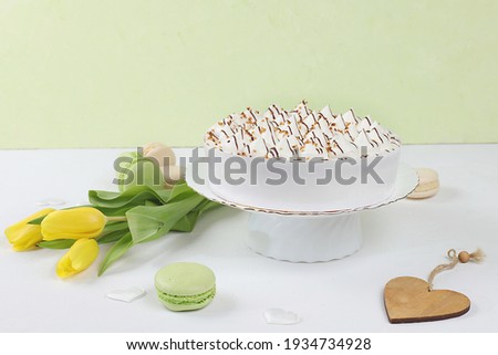 Cake with chocolate and meringue, marshmallow and flowers on a light table, festive food for mother's day, wedding, birthday.Modern bakery concept, advertising space,selective focus, delicious dessert