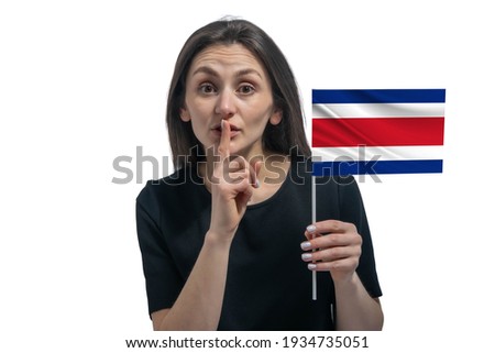 Happy young white woman holding flag of Costa Rica and holds a finger to her lips isolated on a white background.