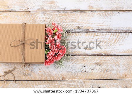 Carnations in a box, abstract spring floral background. Creative modern bouquet, minimal holiday concept. Postcard for womens day or mothers day, happy birthday, wedding, banner for the screen,