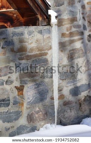 close-up on ice cubes with a stone wall in the background

