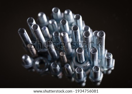 Bolts and nuts on a mirror background.