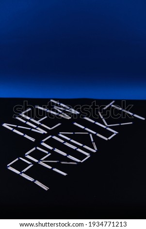 Phrase 'NEW PRODUCT' spelled out with letters made from matchsticks on black and blue background