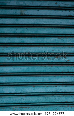 Rolling door is blue. In some parts it has started to rust.